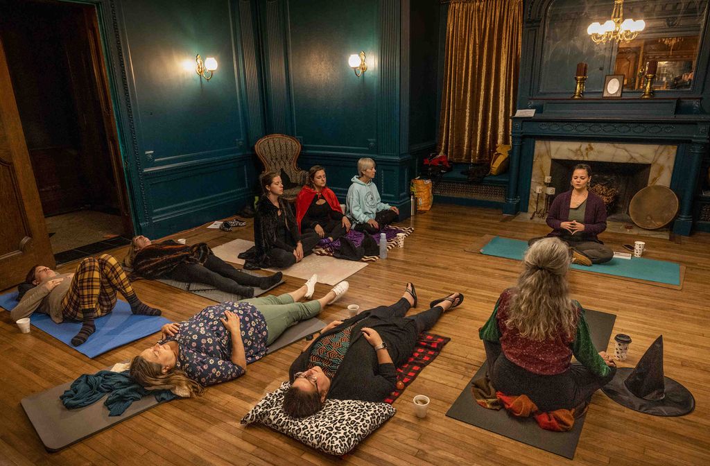 Marissa Fratoni (top right) led a meditation group at the Witchy Wellness Bazaar at the Wheeler Mansion. STEVEN G. SMITH/FOR THE BOSTON GLOBE